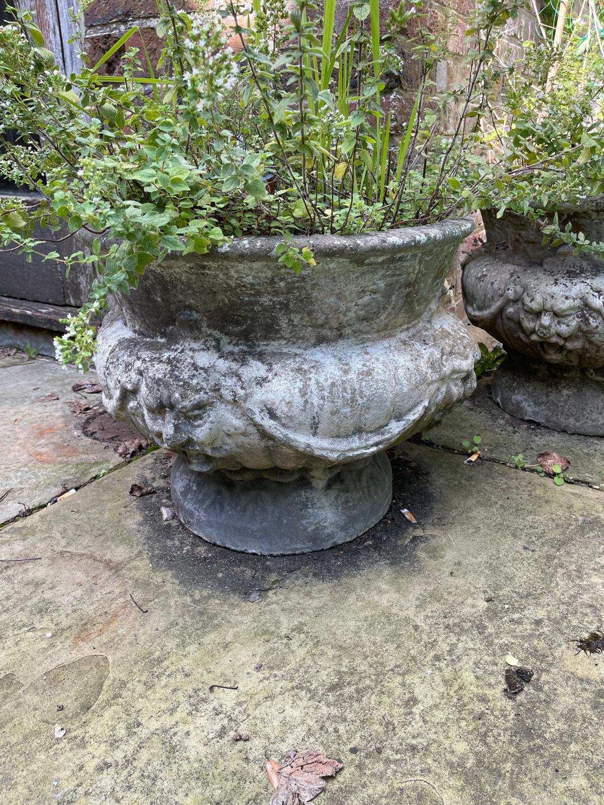 A set of four reconstituted stone circular bulbous garden urns